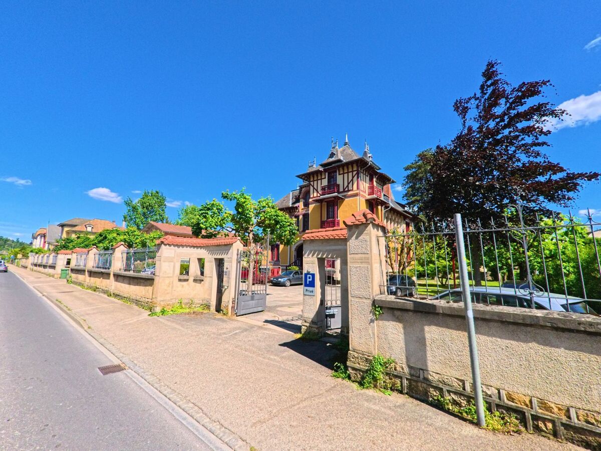 In Porrentruy (2900, Kanton Jura) steht eine aufwendig gestaltete Villa mit Türmchen und rotem Fachwerk hinter einer verzierten Mauer mit Einfahrtstor.