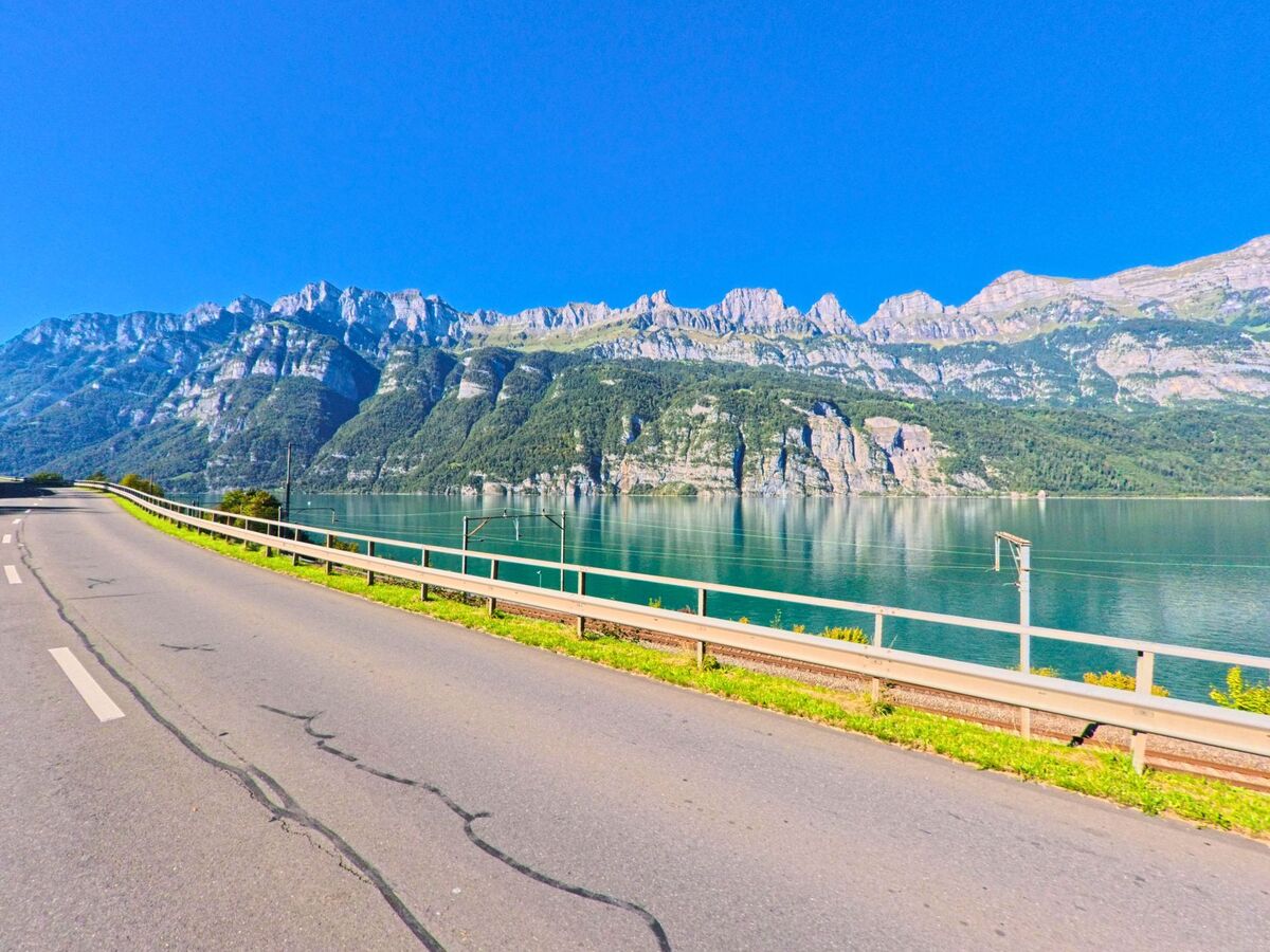 Entlang der Strasse in Quarten (8882, Kanton St. Gallen) fuehrt der Blick ueber den klaren Walensee hin zu den steilen Felswaenden des Churfirsten-Gebirges.