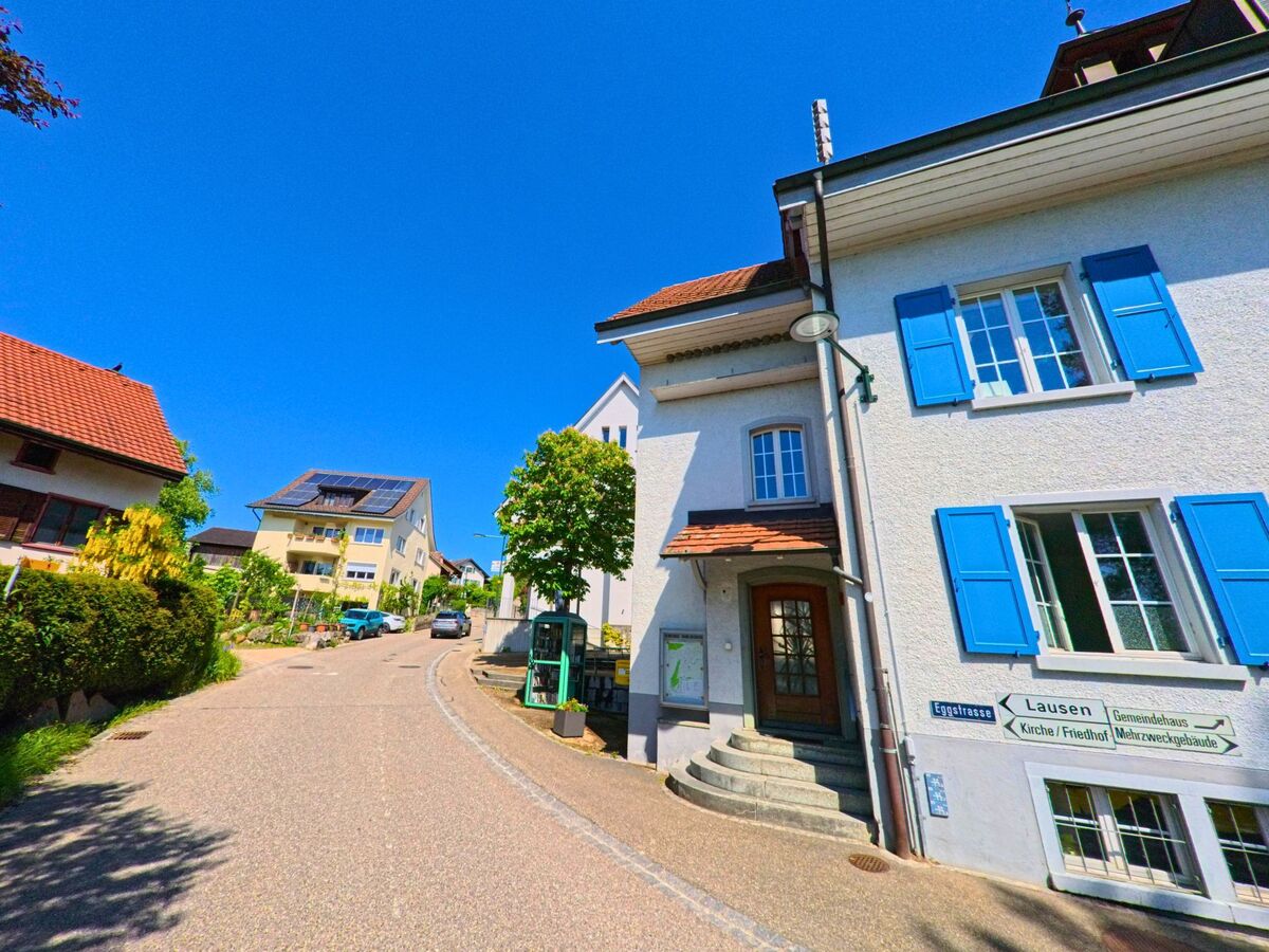 In Ramlinsburg (4433, Kanton Baselland) zeigt ein Wegweiser an einem Haus mit blauen Fensterläden den Weg zur Eggstrasse, zum Gemeindehaus und zur Kirche.