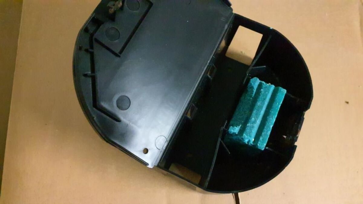 Ein Blick auf einen Rattenköderkasten, der geöffnet und mit grünem Giftköder gefüllt ist.