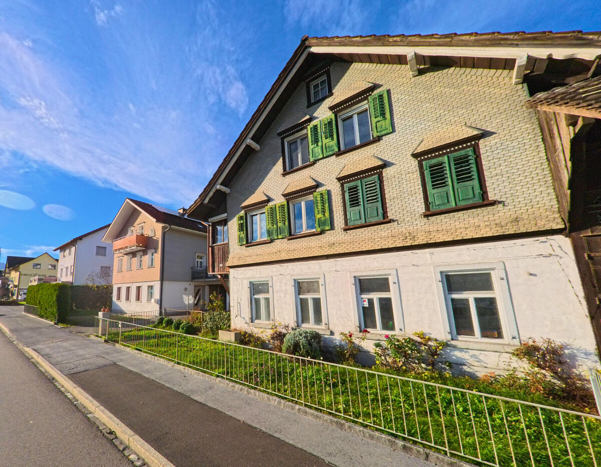 Ein traditionelles Wohnhaus mit Gruenfensterlaeden steht an einer Nebenstrasse in Rebstein (9445, Kanton St. Gallen).