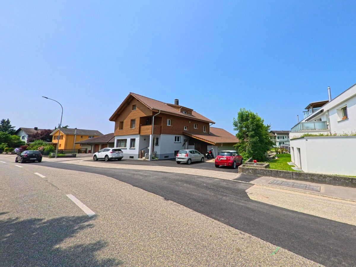 Zwei moderne Häuser stehen entlang einer ruhigen Straße in Recherswil (4565, Kanton Solothurn), wobei ein rotes Auto vor einem der Häuser geparkt ist.