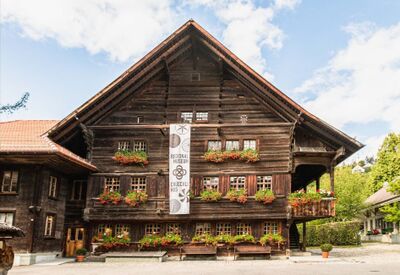 Das Regionalmuseum Chüechlihus in Langnau im Emmental (3550, Kanton Bern) befindet sich in einem historischen Holzhaus mit Blumenschmuck an den Fenstern.