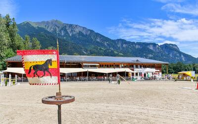 Der Reitverein Falknis aus Maienfeld (7304, Kanton Graubünden) präsentiert eine Reitanlage mit Vereinsfahne, Reitplatz und Bergkulisse im Hintergrund.