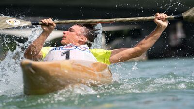 In Basel (4000, Kanton Basel-Stadt) kaempft ein Rennpaddler mit kraftvollem Paddelschlag durch das Wasser, waehrend Spritzer die dynamische Bewegung betonen.
