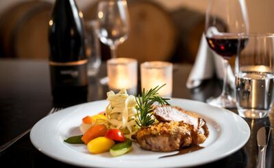 Im Restaurant Commenda in Hitzkirch (6285, Kanton Luzern) liegt ein fein angerichtetes Gericht mit Fleisch, Nudeln und Gemuese auf einem gedeckten Tisch.