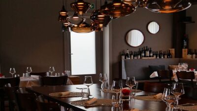 Im Restaurant La Tavola in Risch (6343, Kanton Zug) sorgen dunkle Holztische, elegante Weinglaeser und warme Lichtakzente fuer eine gemuetliche Atmosphaere.