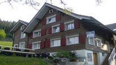In St. Margrethen (9430, Kanton St. Gallen) steht ein traditionelles Gasthaus mit brauner Fassade, roten Fensterlaeden und einer kleinen Aussenterrasse.