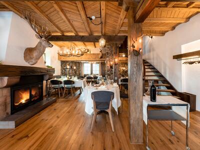 Im Restaurant Roessli in Kirchberg SG (9533, Kanton St. Gallen) sorgt ein rustikaler Speisesaal mit Kamin, Holzbalken und gedeckten Tischen fuer ein gemuetliches Ambiente.