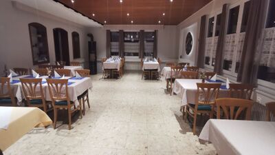 Im Restaurant Sternen Ursellen in Konolfingen (3510, Kanton Bern) sind die Tische mit blauen Akzenten und Stoffservietten in einem hellen Speisesaal gedeckt.
