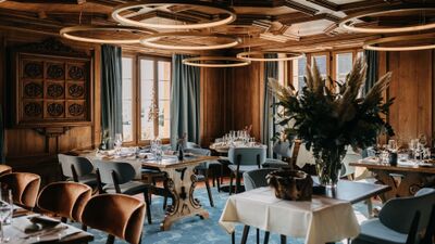 Im Restaurant Wart in Huenenberg (6331, Kanton Zug) verbinden sich moderne Beleuchtung und elegante Holzelemente zu einem stilvollen Speiseraum mit grossen Fenstern.