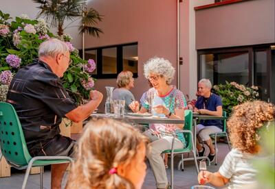 In Wohlen (5610, Kanton Aargau) sitzen Menschen im Aussenbereich eines Restaurants an kleinen Tischen und essen gemeinsam bei warmem Wetter.
