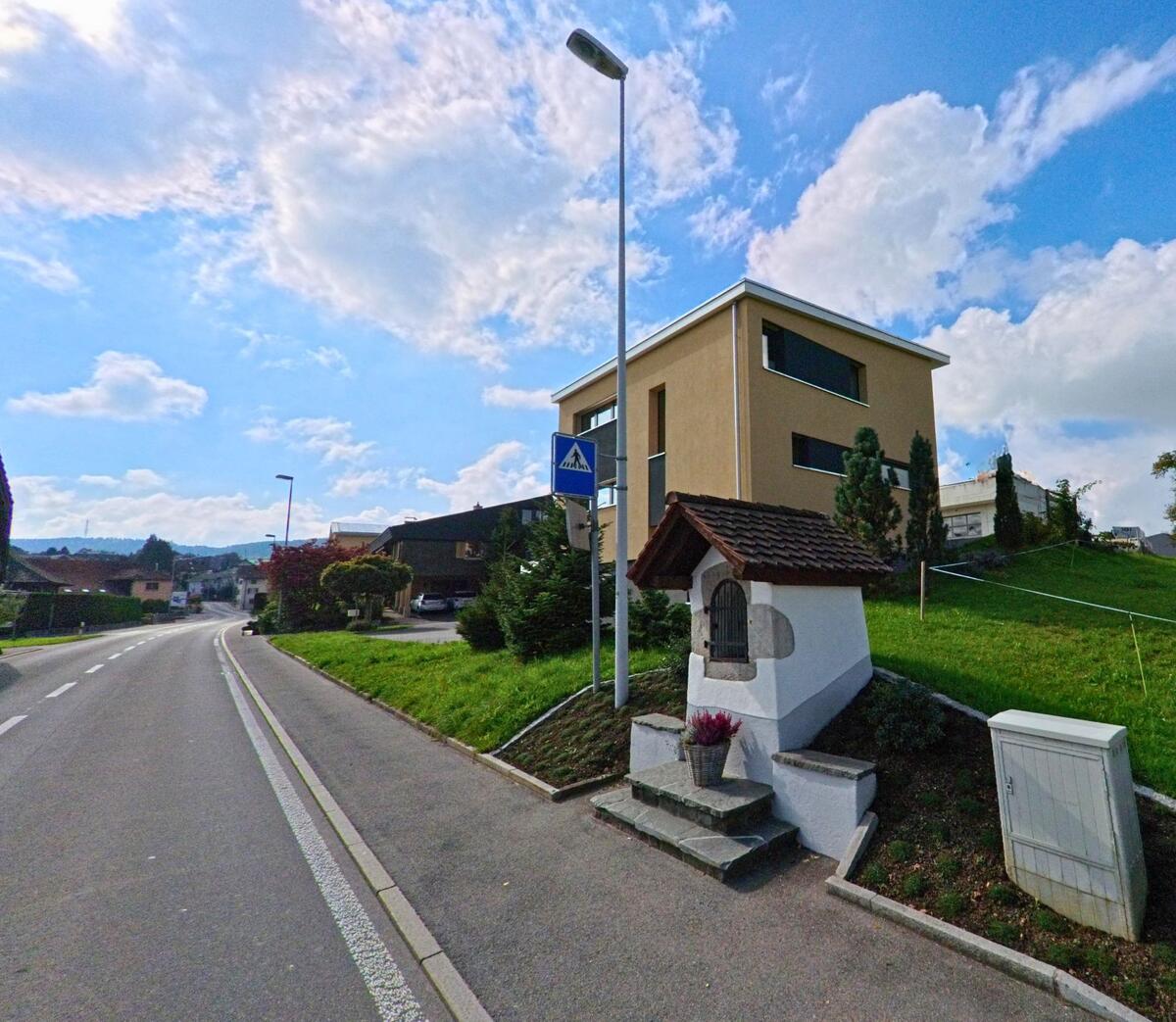 Neben der Strasse steht ein kleines Kapellchen im Siedlungsgebiet von Rickenbach (6221, Kanton Luzern).