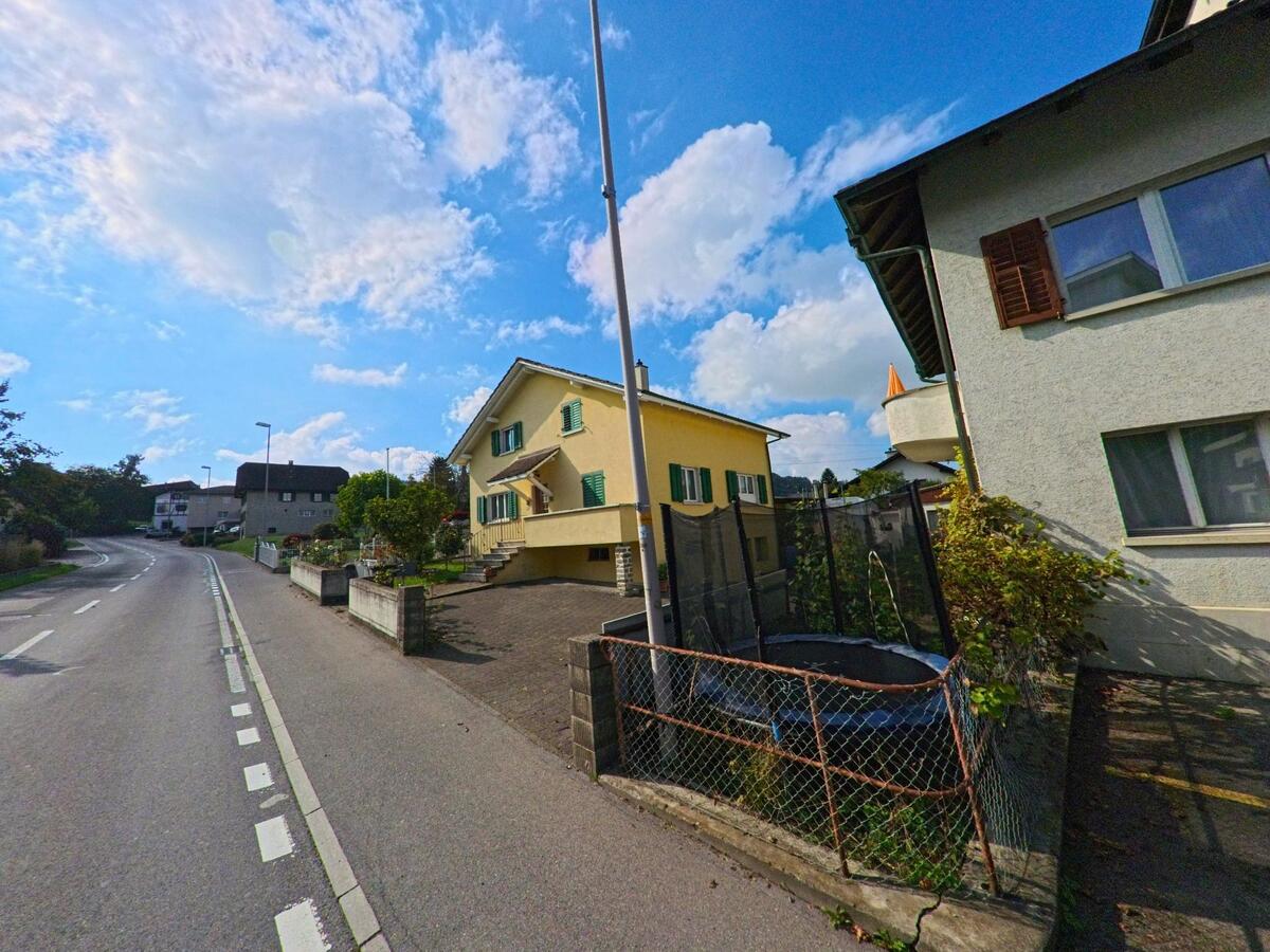 Ein Wohnhang mit Einfamilienhäusern liegt oberhalb der Fahrbahn in Rickenbach (6221, Kanton Luzern).