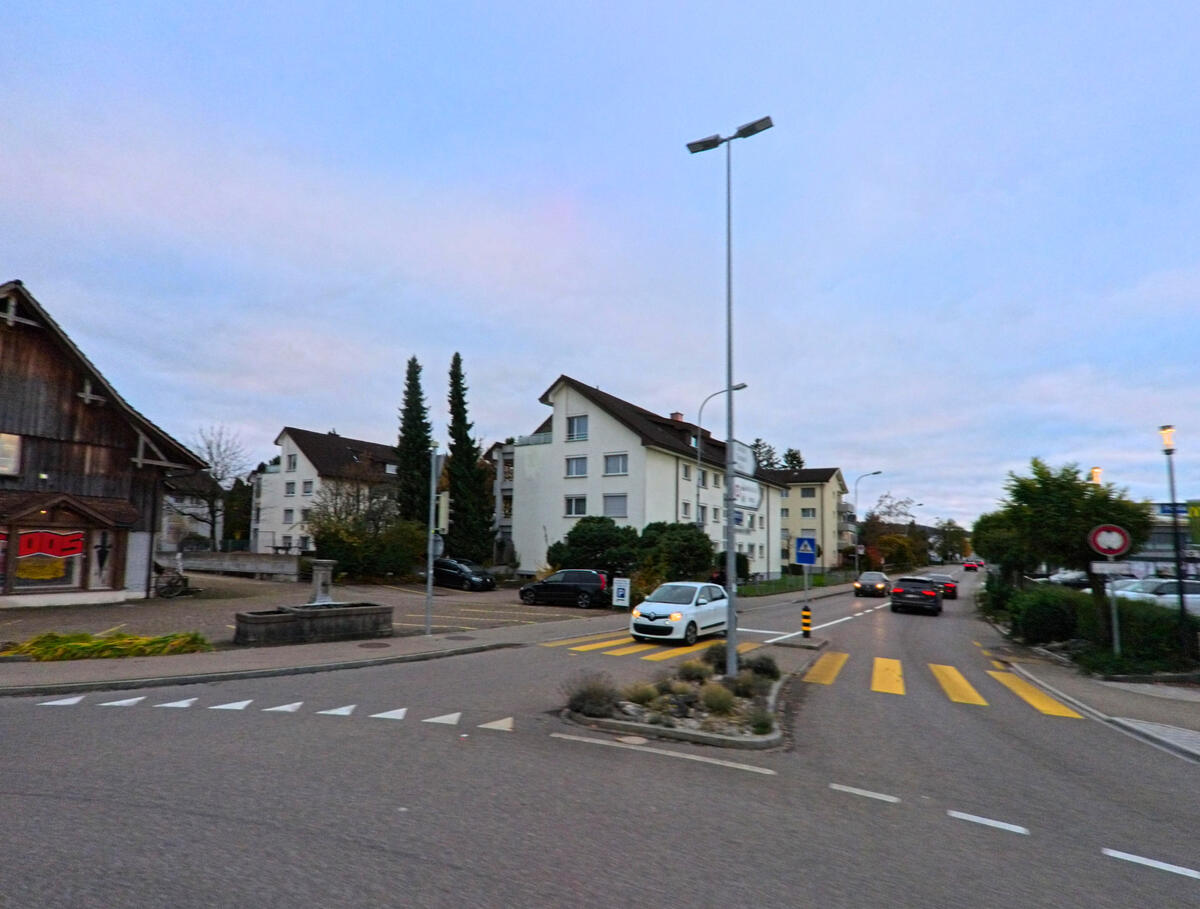 Eine Kreuzung mit Mittelinsel und Fussgängerstreifen strukturiert den Verkehr in Rickenbach (9532, Kanton Thurgau).