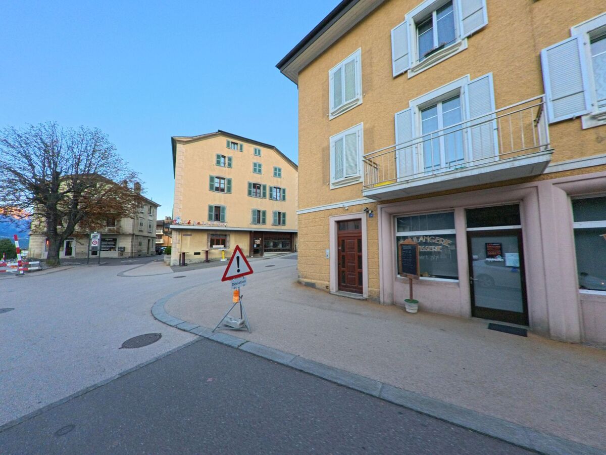 Im Zentrum von Riddes (1908, Kanton Wallis) stehen mehrstöckige Wohn- und Geschäftshäuser mit hellen Fassaden an einer kleinen Platzsituation.