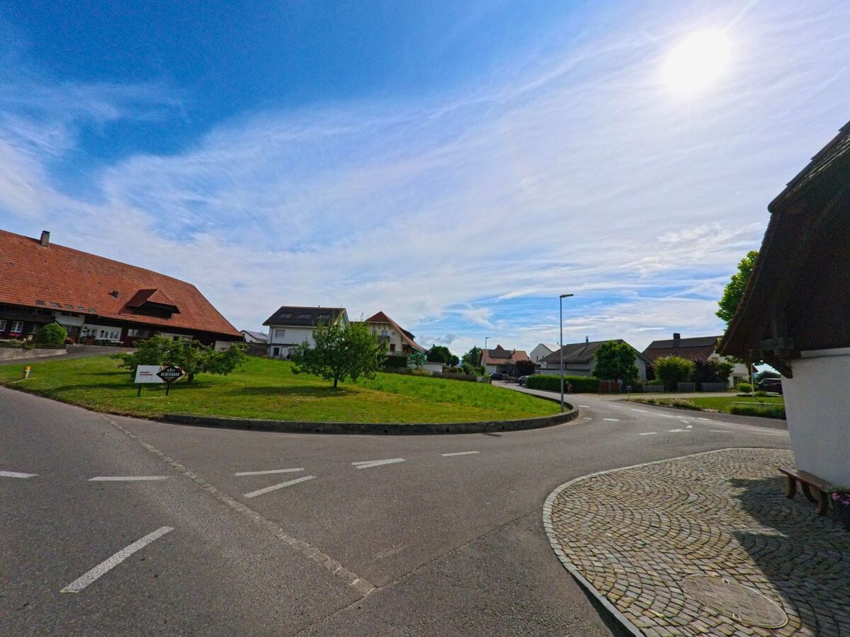 In Ried bei Kerzers (3216, Kanton Freiburg) mündet eine kurvige Strasse in ein ruhiges Wohnquartier mit Einfamilienhäusern und gepflegten Grünflächen.