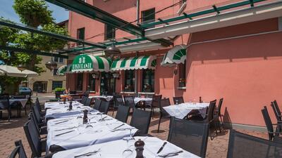 Vor dem Ristorante Sale e Pepe in Moeriken-Wildegg (5103, Kanton Aargau) sind auf der Terrasse unter gruen-weiss gestreiften Markisen Tische festlich eingedeckt.