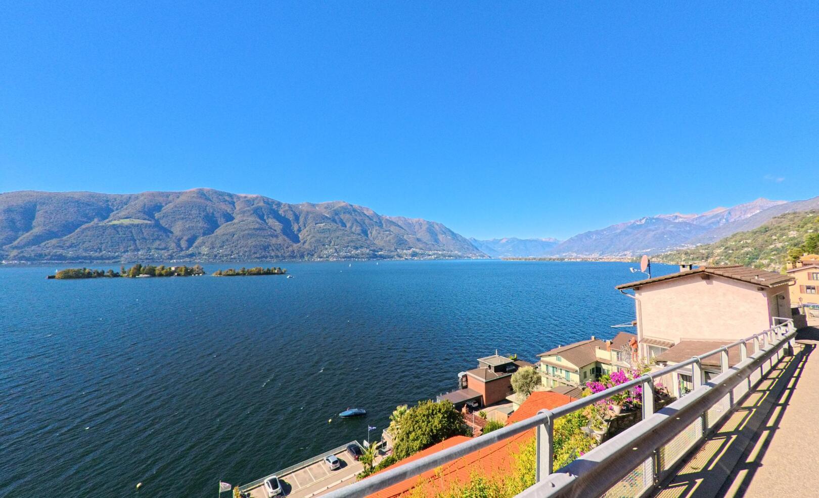 Von einer erhöhten Strasse in Ronco sopra Ascona (6613, Kanton Tessin) öffnet sich der Blick auf den Lago Maggiore und die Brissago-Inseln.