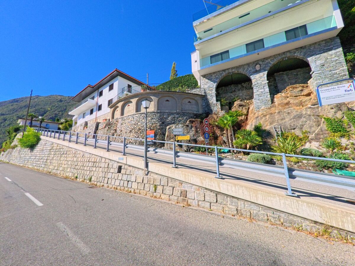 Entlang einer steilen Strasse in Ronco sopra Ascona (6622, Kanton Tessin) stehen moderne und traditionelle Häuser auf terrassierten Steinmauern.
