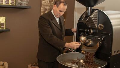 In einer Kaffeerösterei in Adelboden (3715, Kanton Bern) überwacht ein Mann den Röstvorgang frisch gebrannter Bohnen an einer modernen Maschine.