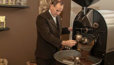 In einer Kaffeerösterei in Adelboden (3715, Kanton Bern) überwacht ein Mann den Röstvorgang frisch gebrannter Bohnen an einer modernen Maschine.