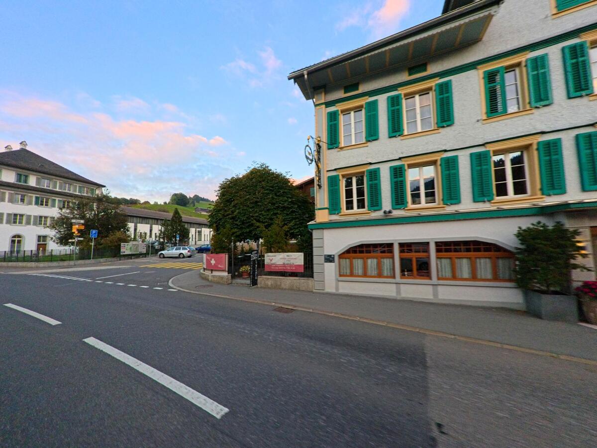 Die Fassade eines traditionellen Gebäudes prägt eine Strassenecke in Rothenthurm (6418, Kanton Schwyz).
