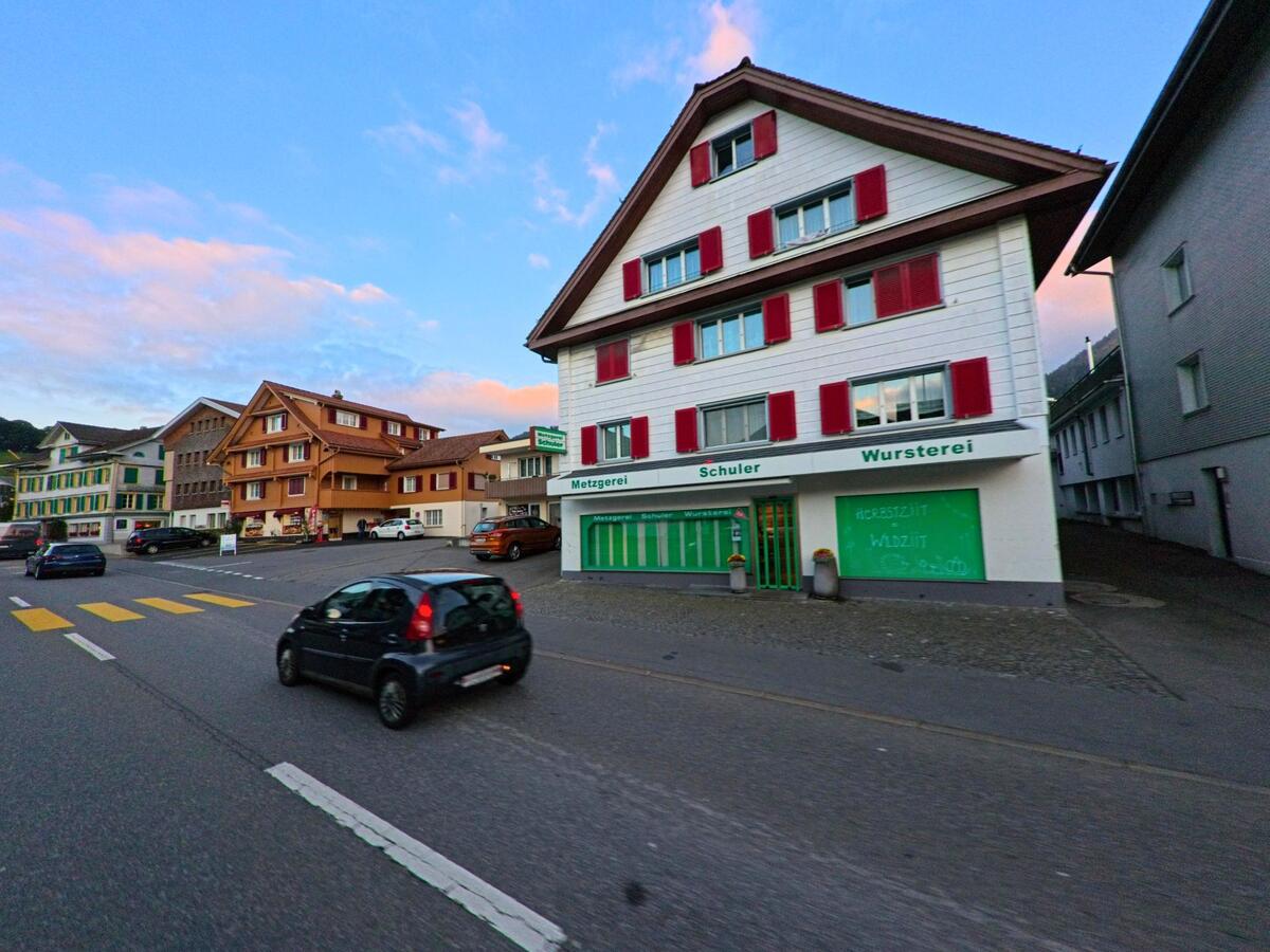Ein Gebäude mit Ladennutzung liegt an einer befahrenen Strasse in Rothenthurm (6418, Kanton Schwyz).