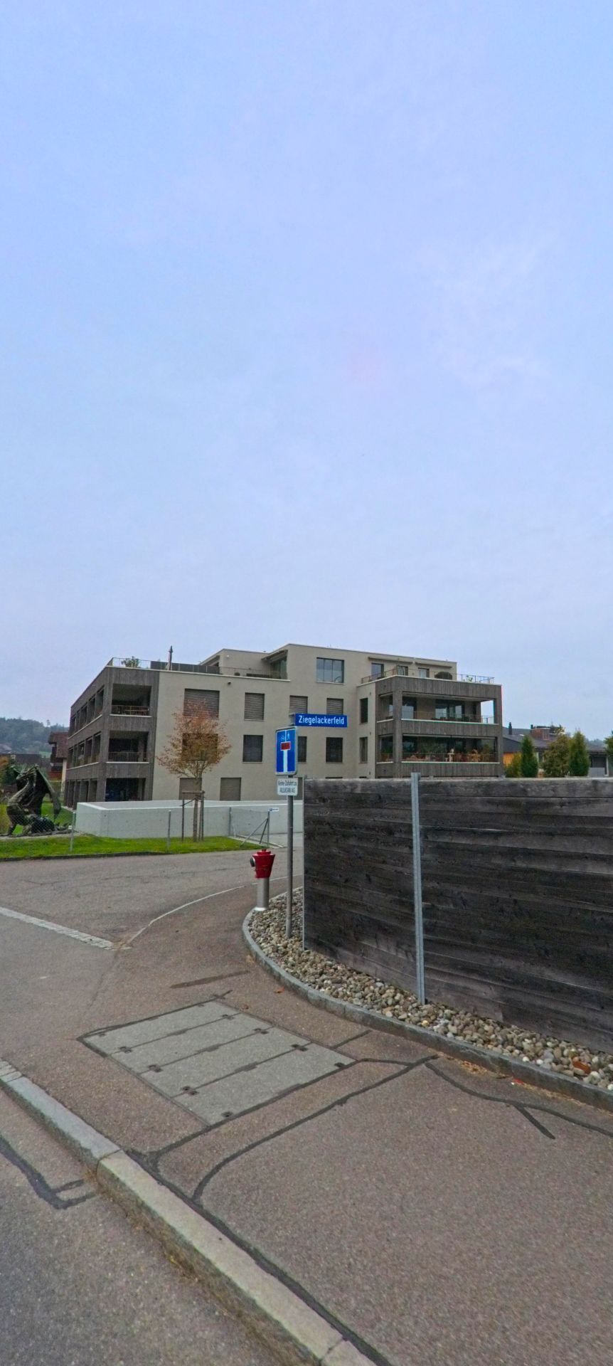 Am Ziegelackerfeld in Rottenschwil (8919, Kanton Aargau) stehen moderne Mehrfamilienhaeuser mit Balkonen und klarer Architektur an einer ruhigen Quartierstrasse.
