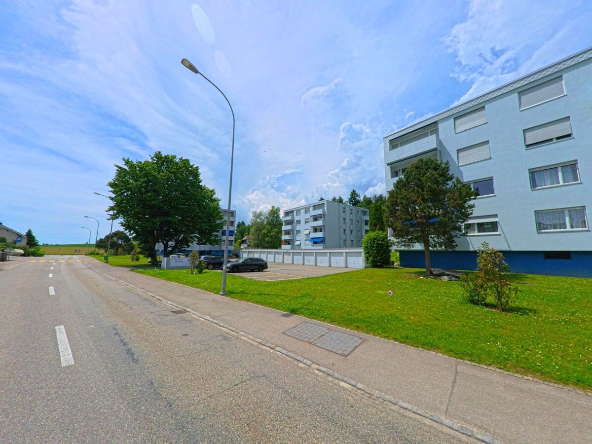 In Rüttenen (PLZ 4522, Kanton Solothurn) säumen mehrere hellblaue Mehrfamilienhäuser mit gepflegten Grünflächen eine ruhige Strasse nahe dem Ortsrand.