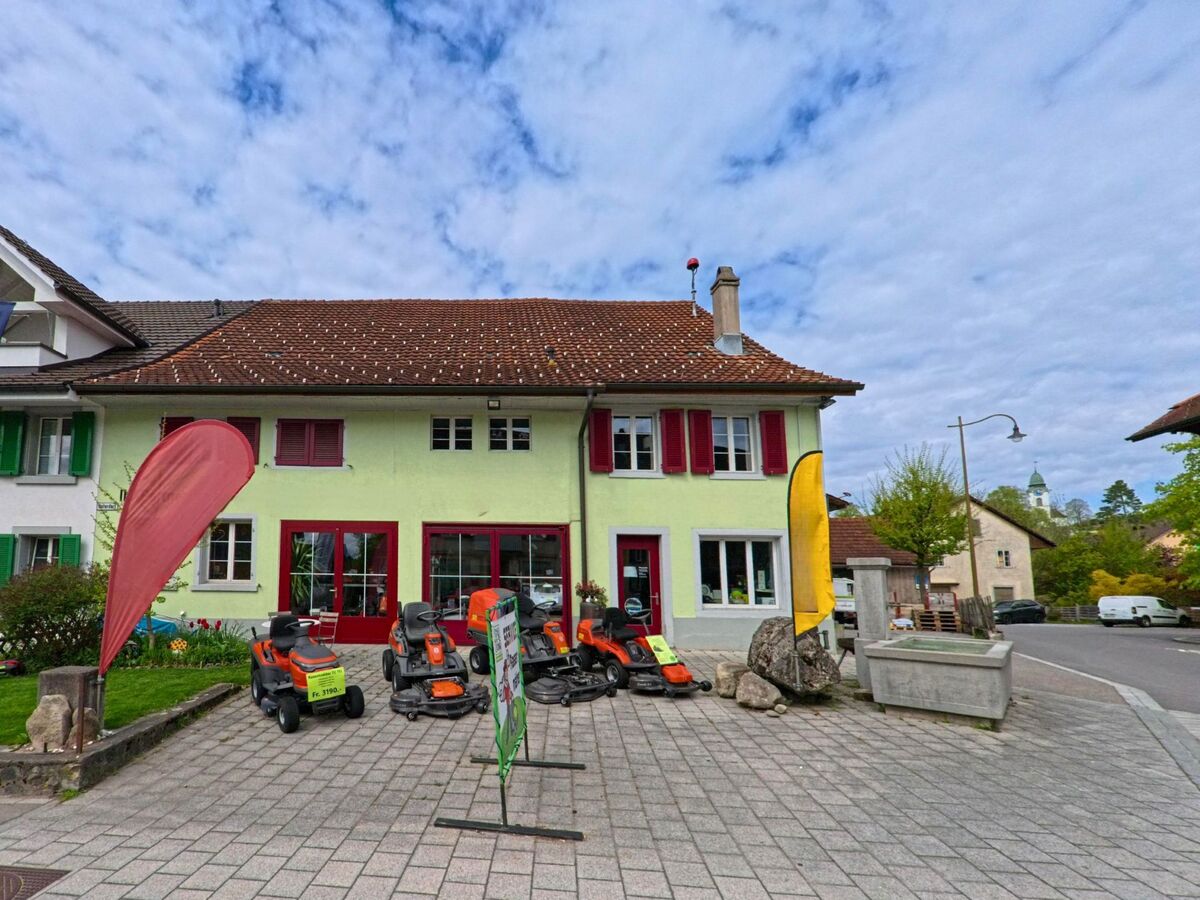  Vor einem Geschäftshaus in Russikon (8332 im Kanton Zürich) stehen mehrere Rasenmähermodelle auf dem gepflasterten Platz zur Schau.