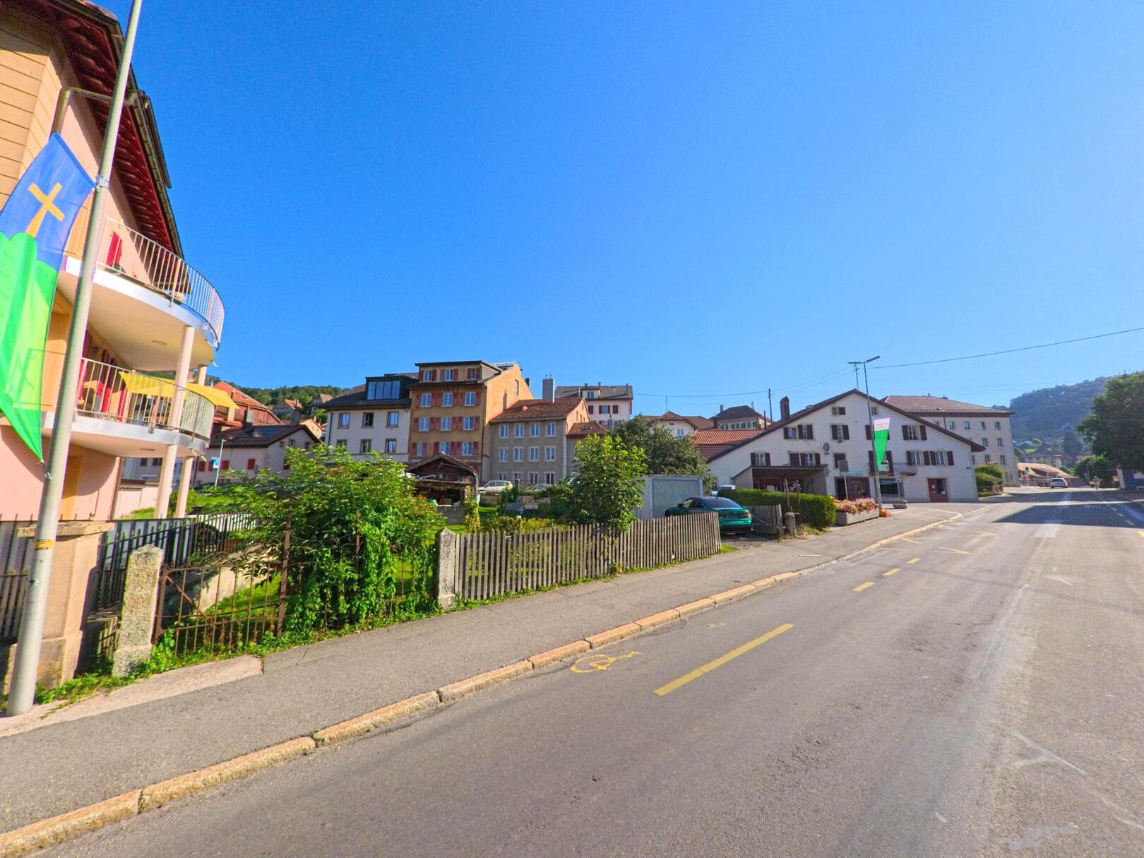Entlang einer Hauptstrasse in Sainte-Croix (1450, Kanton Waadt) stehen mehrstoekige Wohnhaeuser mit unterschiedlichen Fassaden und Balkonen.