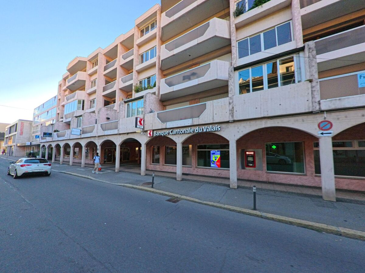Ein Wohn- und Geschaeftshaus in Saxon (1907, Kanton Wallis) beherbergt die Banque Cantonale du Valais an einer belebten Strasse.