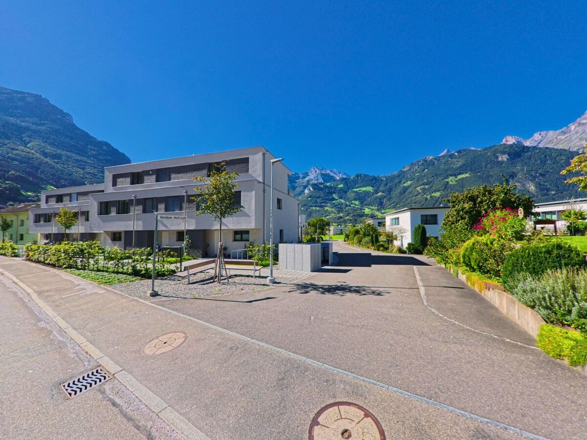 In Schattdorf (6467, Kanton Uri) liegen moderne Wohnbauten an der Vordere Hofstatt vor der eindrucksvollen Bergkulisse des Reusstals.