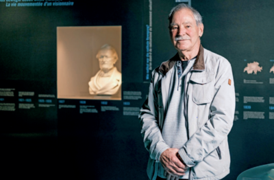 Im Schloss Museum Nidau (2560, Kanton Bern) steht ein Besucher in einer Ausstellung mit historischen Tafeln und einer Bueste, die an die Geschichte der Region erinnert.