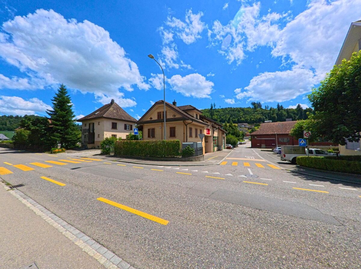Mehrere Fussgaengerstreifen fuehren in Schoeftland (5040, Kanton Aargau) durch eine verkehrsberuhigte Zone mit Wohnhaeusern und einem kleinen Geschaeft am Strassenrand.