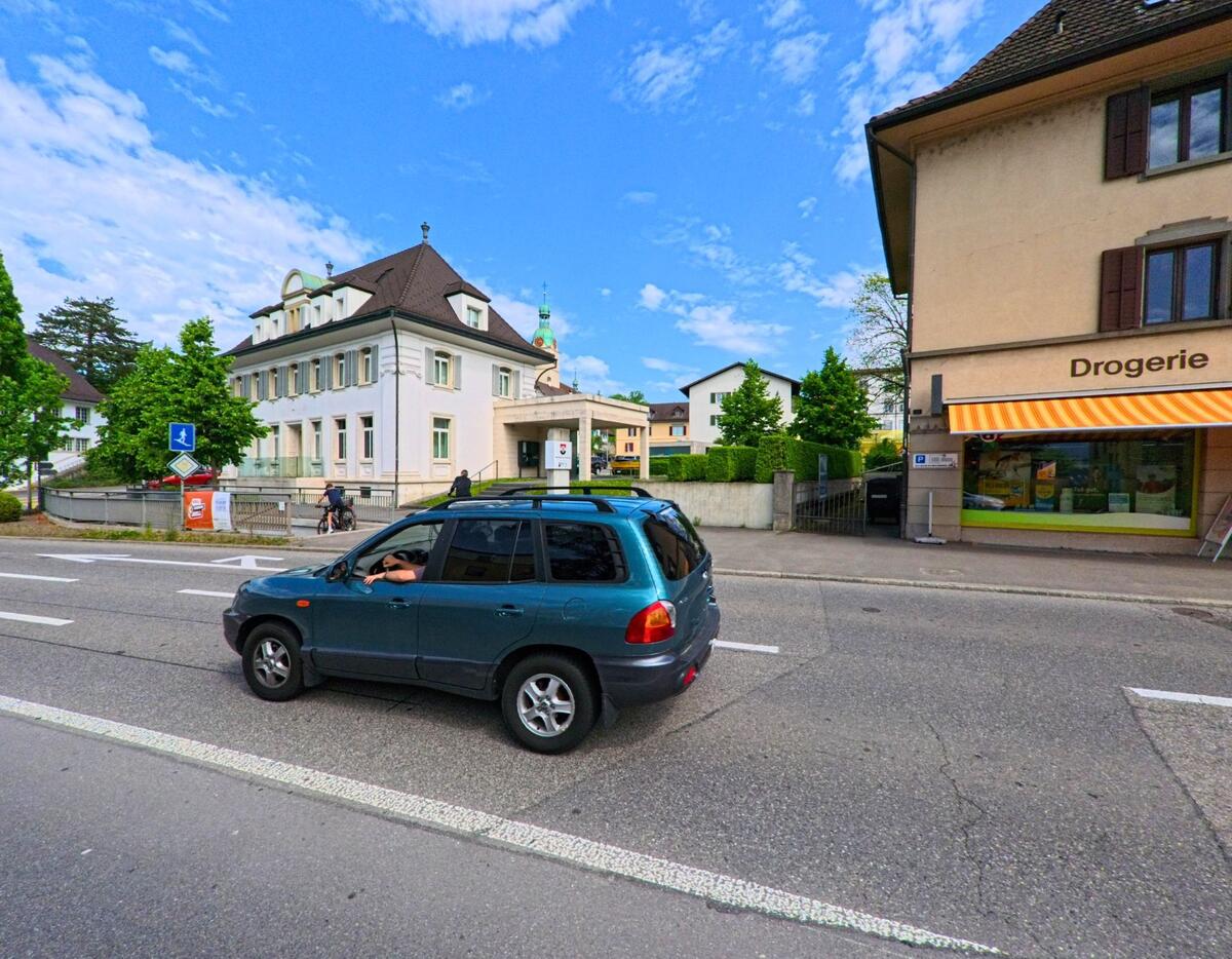 Eine Drogerie an der Hauptstrasse von Schönenwerd (5012, Kanton Solothurn) liegt gegenüber einem weissen Gebäude mit historischem Charakter.