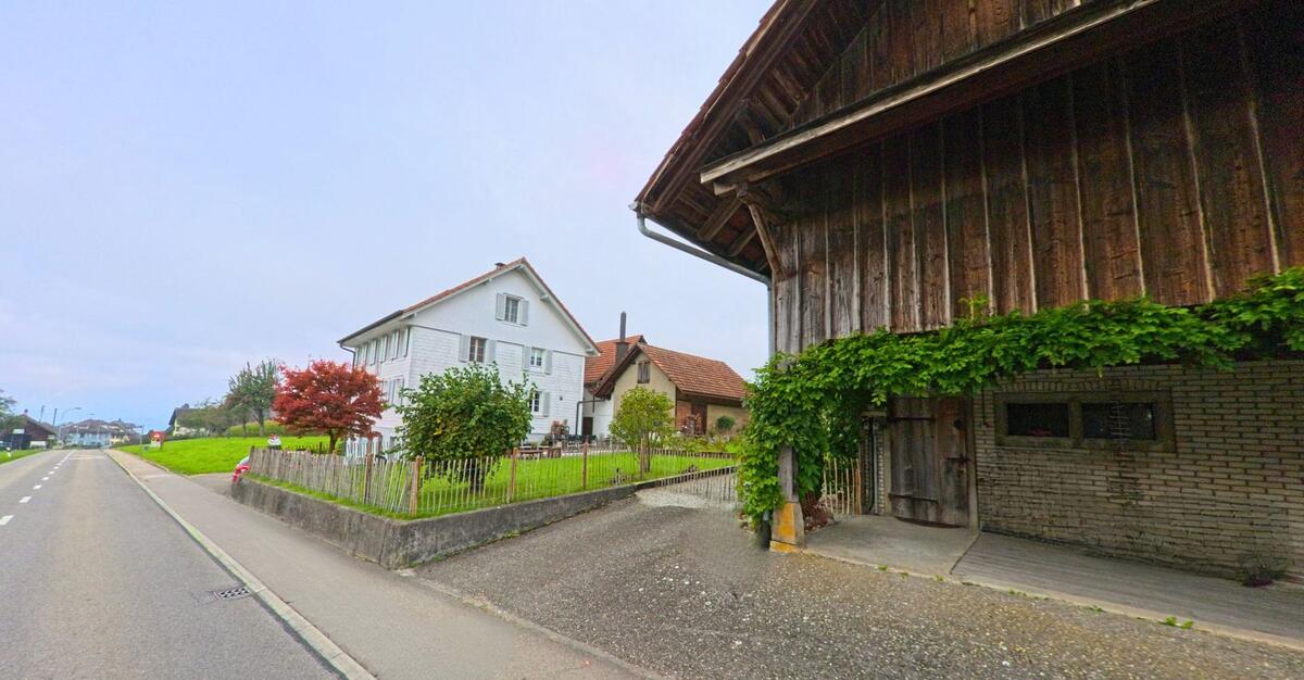 Ein traditionelles Holzhaus steht nahe einer schmalen Zufahrt in Schongau (6288, Kanton Luzern).