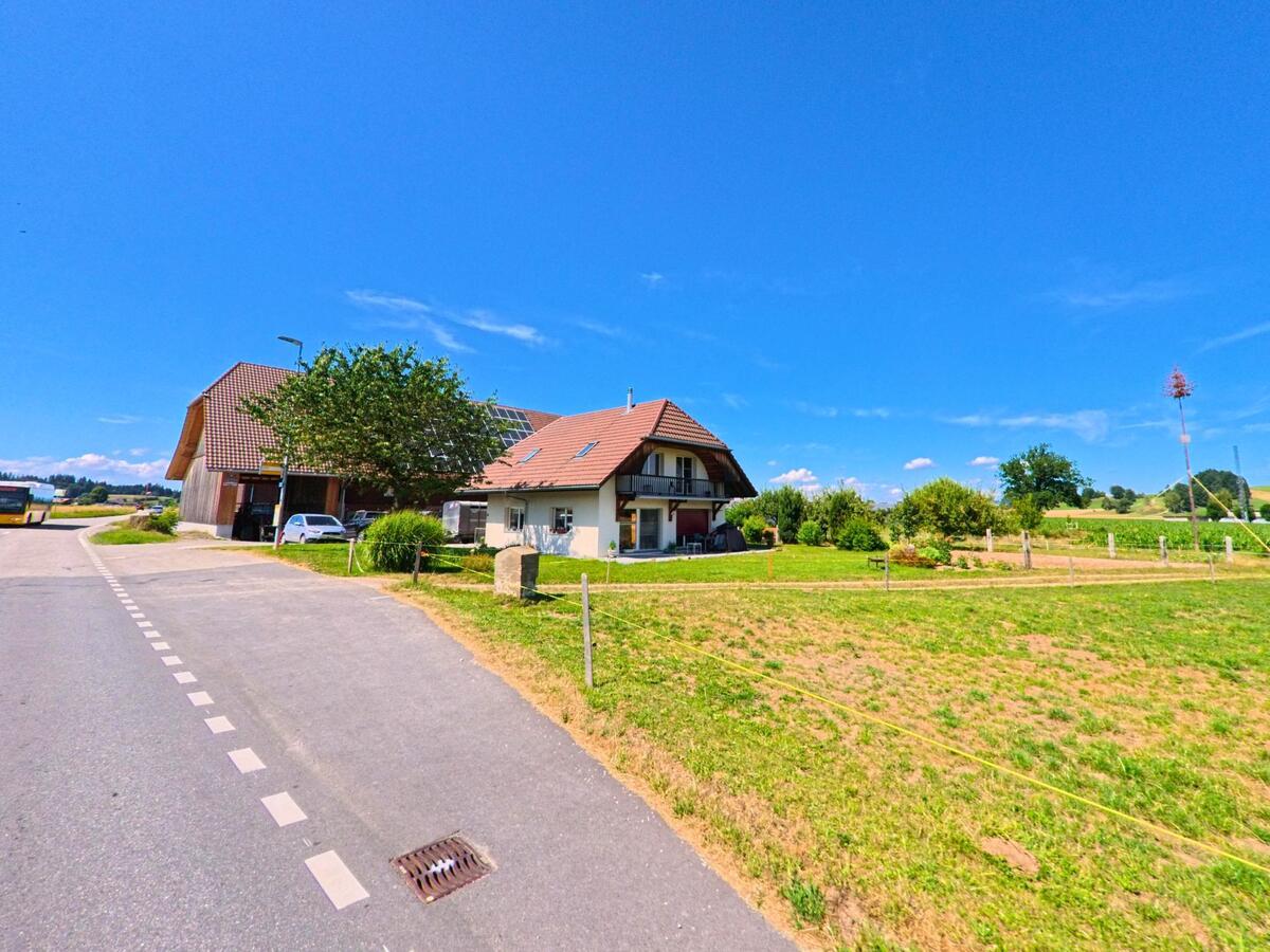 In Schwarzenburg (Kanton Bern, PLZ 3152) steht ein Wohnhaus mit angrenzender Scheune am Rand einer offenen Wiesenlandschaft, nahe einer wenig befahrenen Strasse.