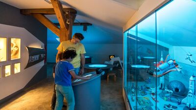 Im Schweizer Kindermuseum in Baden (5400, Kanton Aargau) betrachten ein Vater und sein Kind interaktive Ausstellungsobjekte rund um das Thema Raumfahrt.