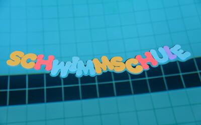 Im Schwimmbecken der Schwimmschule Toggenburg in Nesslau (Kanton St. Gallen) liegen farbige Buchstaben mit dem Schriftzug „Schwimmschule“ auf dem Beckenboden.