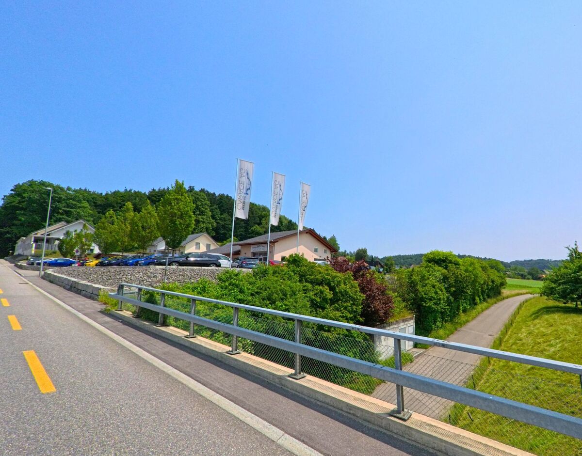 Am Rand von Seeberg (3465, Kanton Bern) liegt ein modernes Gewerbeareal mit Parkplätzen und angrenzendem Veloweg in ländlicher Umgebung.