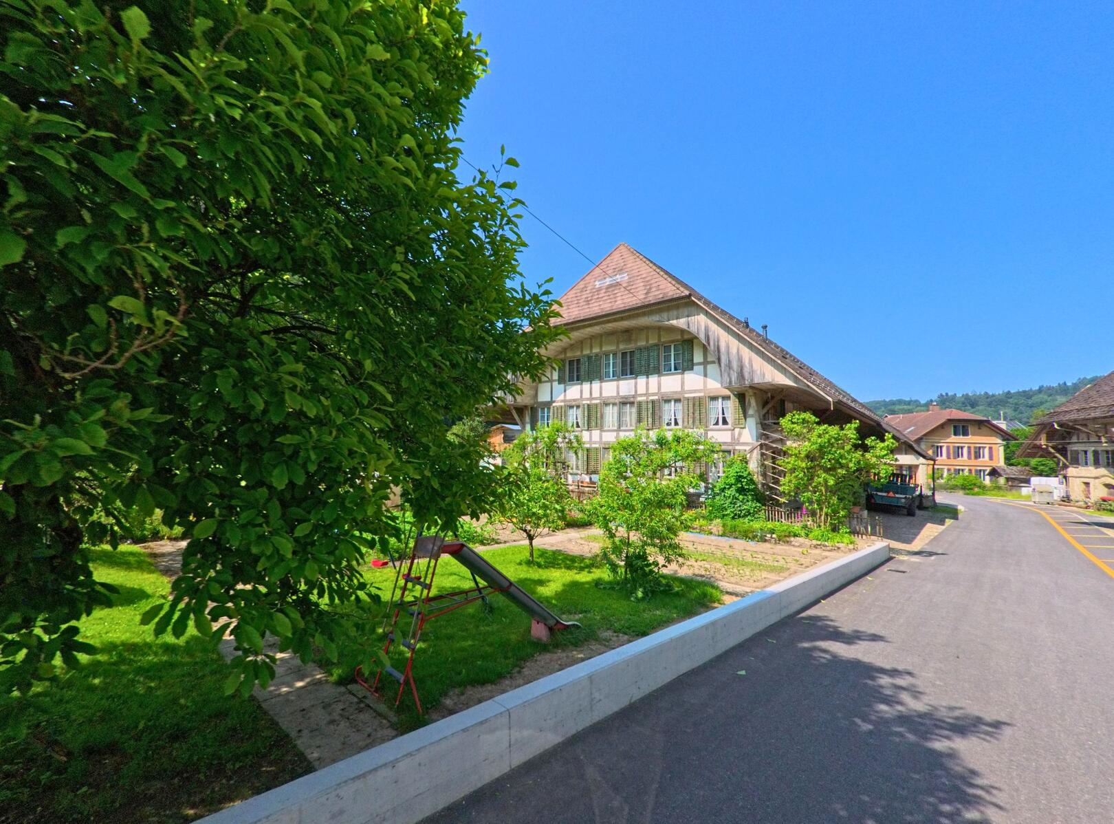 In Seeberg (3475, Kanton Bern) steht ein traditionelles Bauernhaus mit gepflegtem Garten und angrenzendem Spielplatz in einer ruhigen Strasse.
