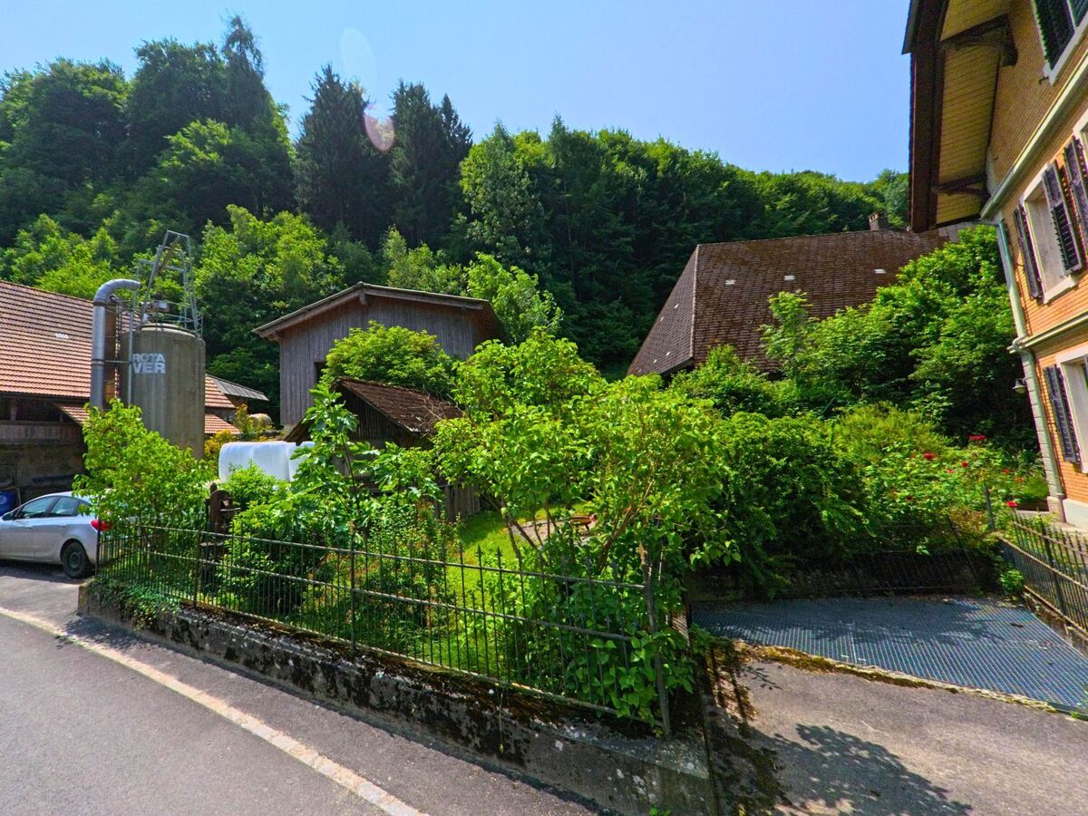 In Seeberg (3475, Kanton Bern) stehen mehrere landwirtschaftliche Gebäude in Hanglage, umgeben von dichter Vegetation am Waldrand.