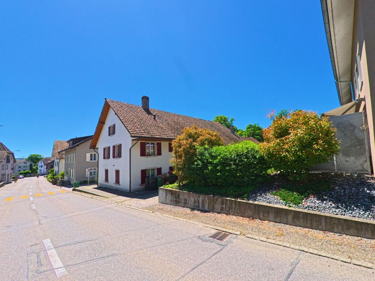 Entlang einer ruhigen Strasse in Selzach (2545, Kanton Solothurn) stehen traditionelle Wohnhäuser mit Fensterläden und gepflegten Vorgärten.