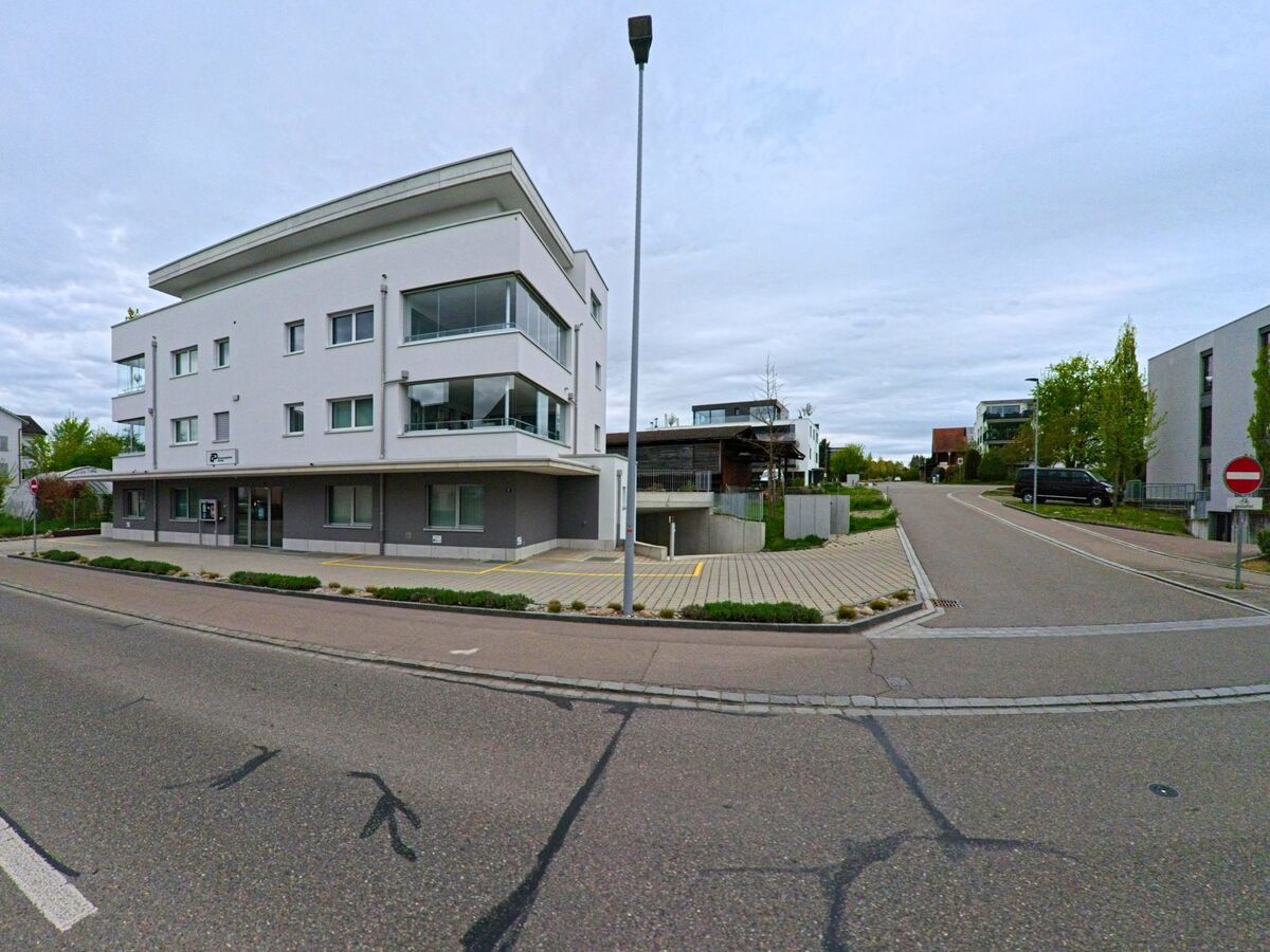 In Seuzach (8472, Kanton Zürich) steht ein modernes Wohn- und Geschäftsgebäude an einer verkehrsberuhigten Seitenstrasse mit Einfahrt zur Tiefgarage.