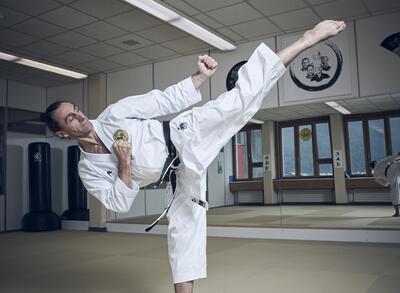 In einem Dojo zeigt ein Karateka in Chur (7000, Kanton Graubünden) eine hohe Tritttechnik während eines Trainings.