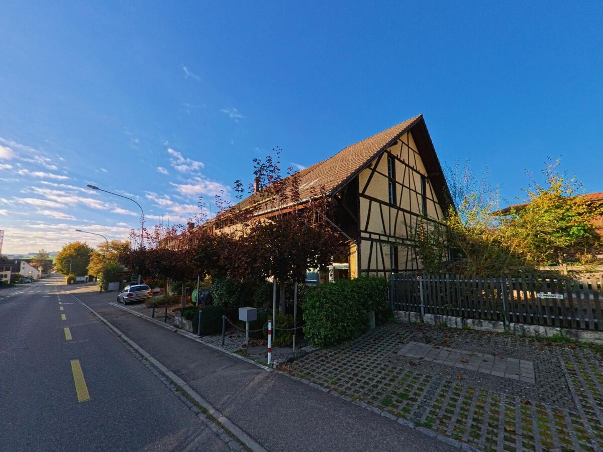 Ein Fachwerkhaus mit Garten befindet sich entlang einer schmalen Fahrbahn in Siblingen (8225, Kanton Schaffhausen).