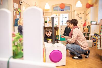 In einem liebevoll eingerichteten Spielraum spielen Kinder in Güttingen (8594, Kanton Thurgau) gemeinsam mit einer Betreuungsperson an einer selbstgebauten Spielstation.