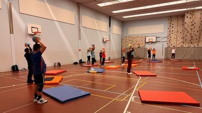 In einer Turnhalle in Dübendorf 8600 im Kanton Zurich trainieren Teilnehmende mit Baellen und Matten gemeinsam bei einem vielseitigen Bewegungsprogramm